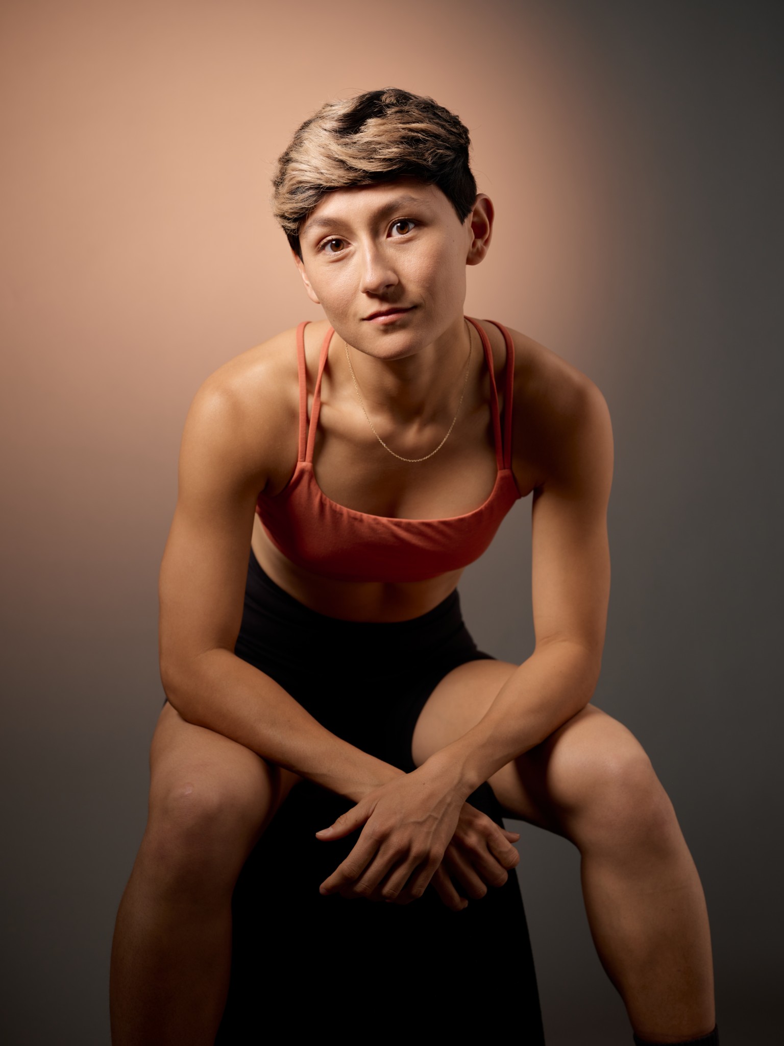 Direct studio portrait of an athlete leaning toward the camera.